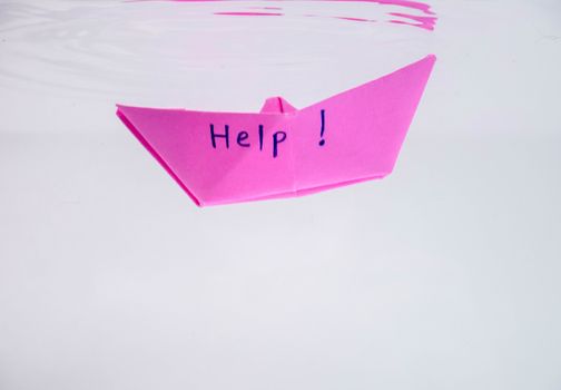 Close-up of sinking folded paper boat into the water. Mental state and Emotional concept.