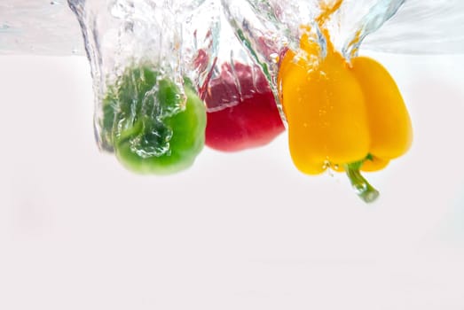 Colorful of sweet pepper thrown into clear water.