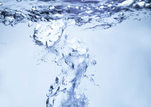 Air bubbles rising up to surface in blue pure water. Abstract background.