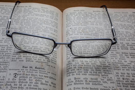 Glasses on book as a magnifying glass