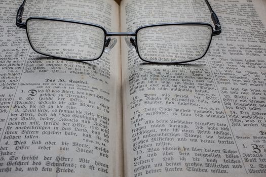 Glasses on book as a magnifying glass