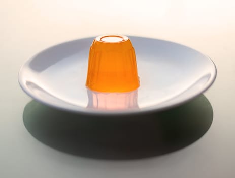 Close up of a orange gelatin on a white plate.