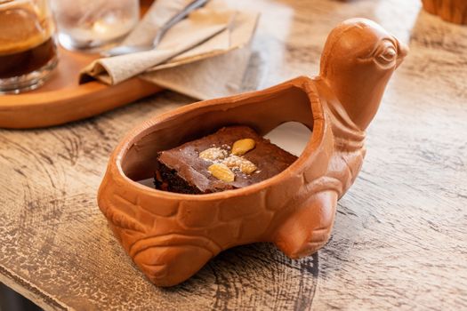 brawny cake served in earthen ware on the table