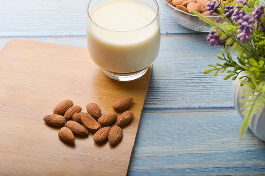 Almond nuts in a glass bowl on a wooden background. Selective focus.