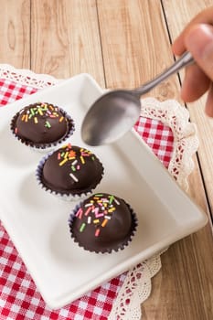 Fresh chocolate ball cakes sprinkled with colorful sugar balls.