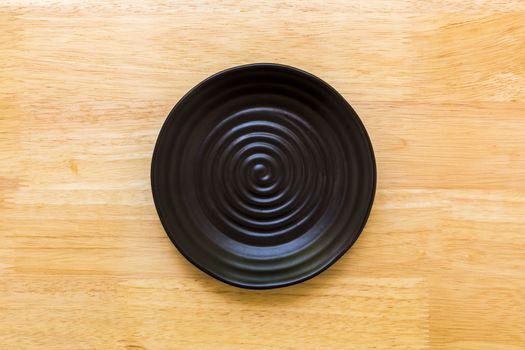 Empty plate without spoon and fork on table background.