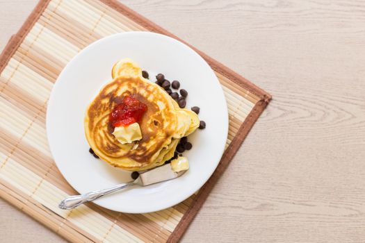 Fresh and hot pancakes to be eaten with butter, strawberry, and chocolate.