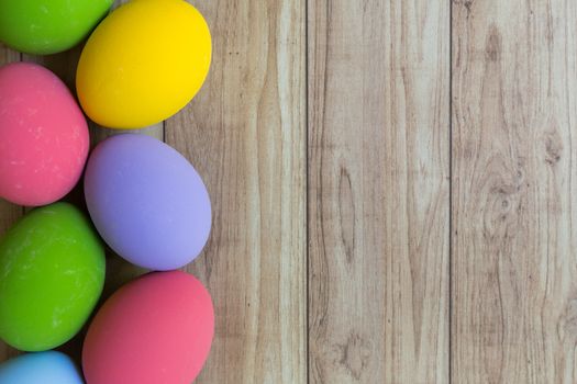 Groud of colorful eggs on wood background.