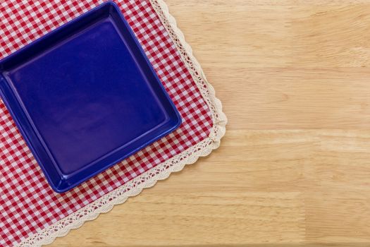 Empty plate without spoon and fork on table background.
