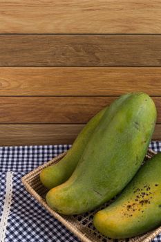 Mangoes from Thailand put in a basket on wood background.
