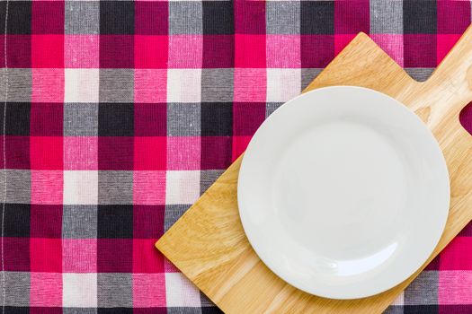 Empty plate without spoon and fork on table background.