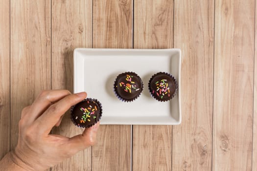 Fresh chocolate ball cakes sprinkled with colorful sugar balls.