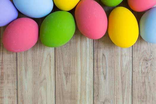 Groud of colorful eggs on wood background.