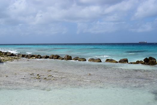 Aruba, Renaissance Island, Caribbean Sea. Sunny beach with white sand, coconut palm trees and turquoise sea. Summer vacation, tropical beach and pink flamingos