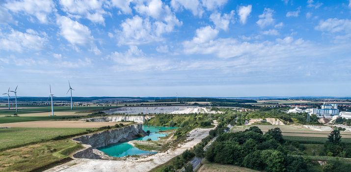 Limestone break from the distance, wind turbines in the background, dramatic sky, aerial photo with the drone