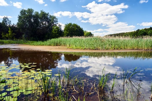 Rural landscape with a lake on a cloudy day in Poland