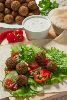 Falafel on salad leaves with tomatoes, cucumber and pepper