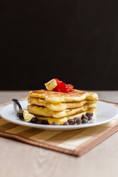 Fresh and hot pancakes to be eaten with butter, strawberry, and chocolate.