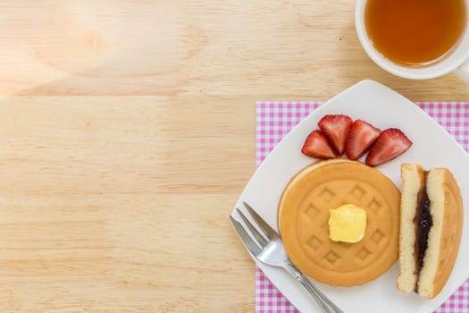 Background of waffle and tea on wooden table for tea break or coffee break.