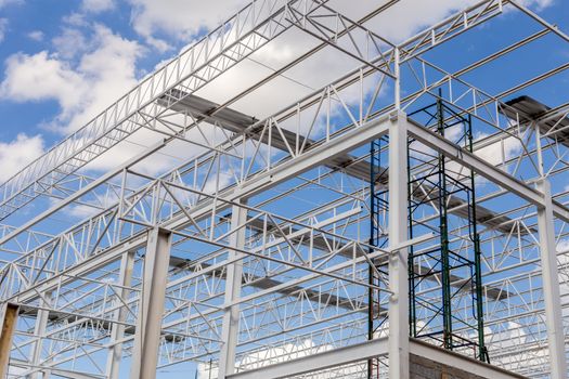 Construction of steel frame of big building with blue sky background.