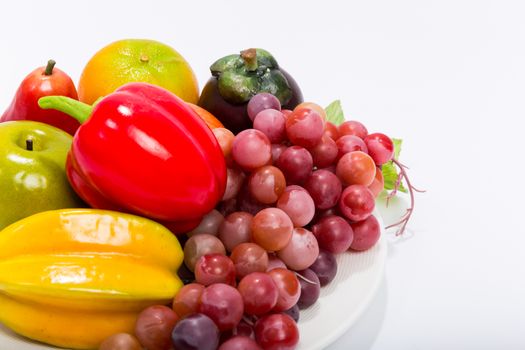 Various kinds of fruits in plate isolated on white background.
