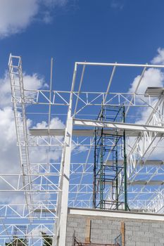 Construction of steel frame of big building with blue sky background.