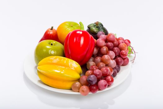Various kinds of fruits in plate isolated on white background.