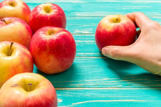 Group of red apple on blue wooden background.