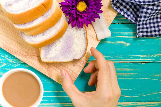 Taro bread with coffee for breakfast on vintage wooden background.