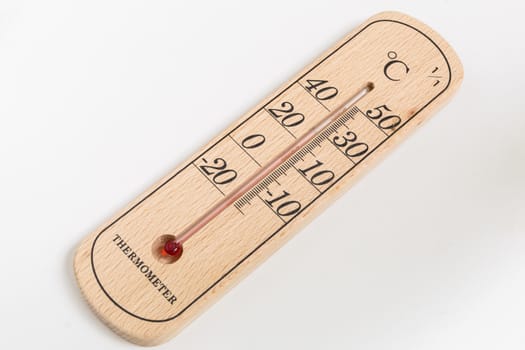 Thermometer made from wood on white background with 30 degree Celsius temperature.