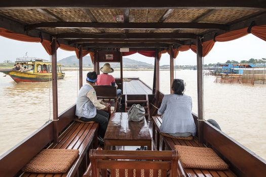 European tourist (lady) on a private cruise tour  with her guide going to visit the a village on the famous Tonle Sap Lake, Siem Reap, Cambodia, Asia