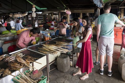 Krong Kaeb, Kep Province, Cambodia, 30 March 2018. Girls buying seafood skewers at the Crab Market