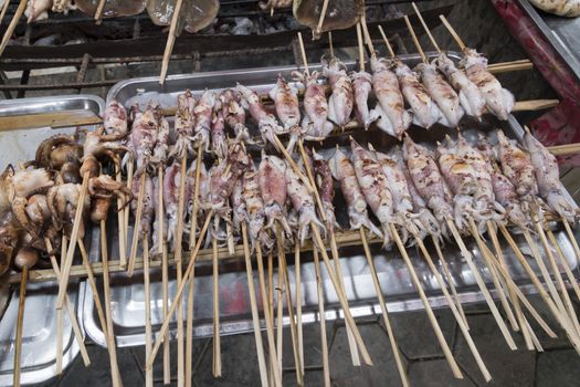 Krong Kaeb, Kep Province, Cambodia, 31 March 2018. Octopus skewers on a grill ready to eat