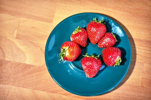 Strawberries on a porcelain plate during spring in Poland