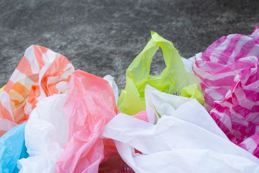 Colorful plastic bags on cement floor background