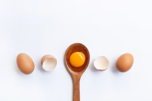 Eggs, egg yolk on wooden spoon isolated on white background.
