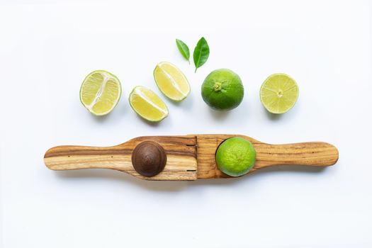 Limes with wooden lime Squeezer on white background.