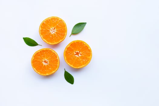 Fresh orange citrus fruit with green leaves on white background.