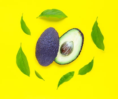 Avocado  with leaves on yellow background. Top view