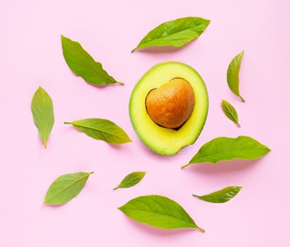 Avocado  with leaves on pink background. Top view