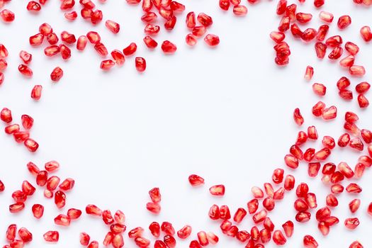 Frame made of pomegranate seeds isolated on white background. Copy space