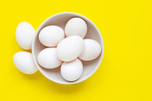White eggs on yellow background.  Top view