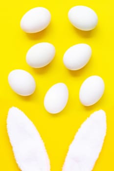 cute bunny ears with eggs on yellow background. Easter concept