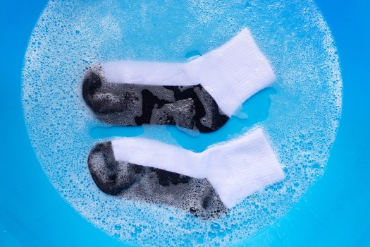 Dirty socks soaking in powder detergent water dissolution. Laundry concept