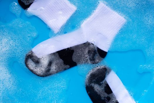 Dirty socks soaking in powder detergent water dissolution. Laundry concept