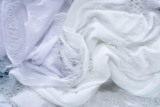 Soak white clothes in powder detergent water dissolution. Laundry concept