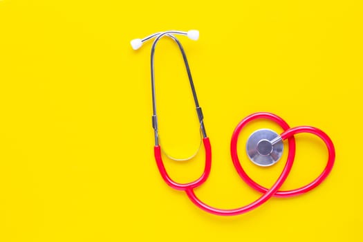 Stethoscope on yellow background with copy space
