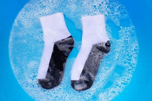 Dirty socks soaking in powder detergent water dissolution. Laundry concept