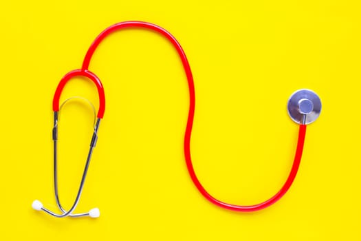 Stethoscope on yellow background with copy space