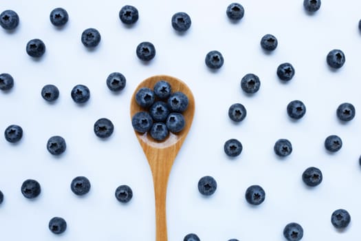 Blueberries with wooden spoon isolated on white background. Top view